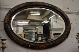 An oval wall mirror with chinoiserie decorated frame.