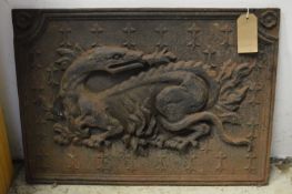 A cast iron fire back depicting a dragon.