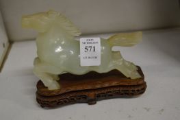 A Chinese carved jade model of a prancing horse on hardwood stand.