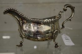 A good Georgian silver sauce boat with engraved armorial on three shell cast feet.