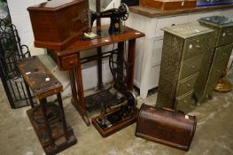 A Singer treadle operated sewing machine together with a table top sewing machine.