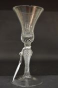 A 19th century Continental wine glass with inverted bell shaped bowl and clear air twist knopped