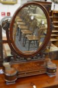 A Victorian mahogany oval shaped dressing table mirror with storage compartments to the base.