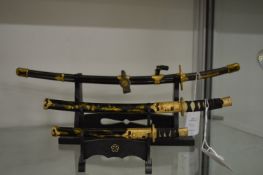 Miniature Samurai swords on stands.