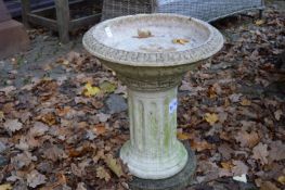 A reconstituted stone circular bird bath.
