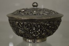 A Chinese cast white metal bowl and cover decorated with birds and flowers.