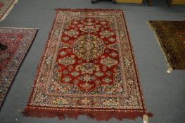 A Persian style rug, red ground with floral decoration, 187cm x 118cm.