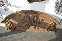 A large carved oak door or archway cresting.
