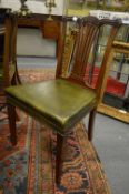 A set of eight Edwardian mahogany dining chairs with green leather upholstered seats.