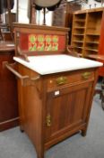 A small Victorian walnut washstand with marble top and tiled splash back.