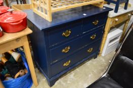 A dark blue painted chest of drawers.