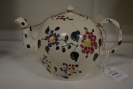 A floral decorated cream ware bullet shaped teapot (faults).