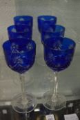 A set of six blue and clear cut glass wine glasses.
