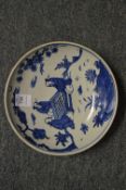 A Chinese blue and white circular dish painted with figures play a game.