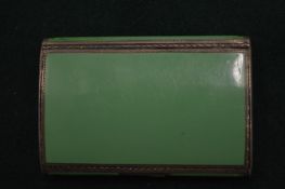 A small silver and green enamel cigarette case.