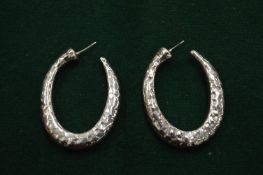 A pair of silver earrings.