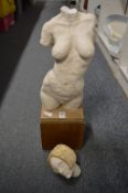 A plaster maquette of a female nude on a wooden base (af).