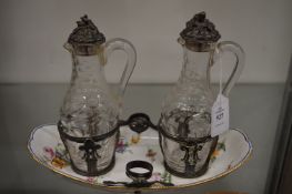 A Continental floral decorated porcelain double cruet with cut glass bottles and possibly silver
