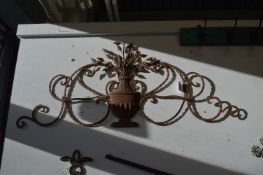 Wrought iron wall sculpture as a vase of flowers.