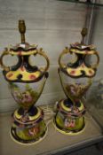 A large pair of decorative pottery twin handled lamps with circular bases.