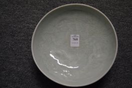 A Chinese celadon glazed circular dish with incised decoration.