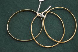 Three yellow metal bangles, each stamped 22ct.