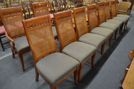 A set of ten hardwood dining chairs with striped upholstered seats and cane work back panels, two