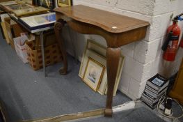 A walnut console table with serpentine fronted top on carved cabriole legs.