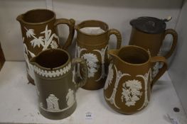 A group of five brown Jasperware style jugs.