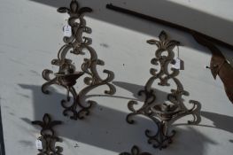 A pair of wrought iron wall mounted candle holders.