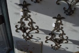 A pair of wrought iron wall mounted candle holders.