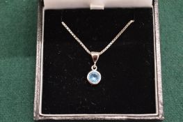 A silver pendant and chain set with a single blue stone, possibly aquamarine.