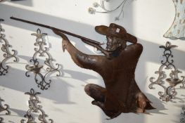 A moulded tin wall sculpture or shop sign modelled as a hunter firing a rifle.