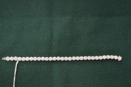 A very good 18ct white gold and illusion set diamond line bracelet.