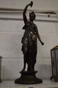 A cast bronze figure of a classical young lady holding a torch.