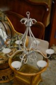A white painted wrought iron candle chandelier.