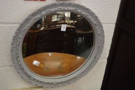 A convex mirror with grey painted frame.