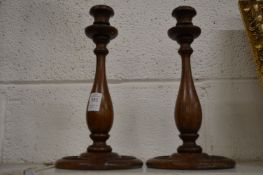 A pair of turned oak candlesticks.