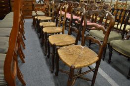 Six French elm and rush seated ladder back dining chairs.