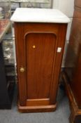A Victorian mahogany and marble topped pot cupboard.