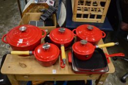 A quantity of red enamel cast iron cookware.