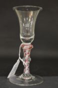 A Georgian wine glass with inverted bell shaped bowl and coloured air twist stem.