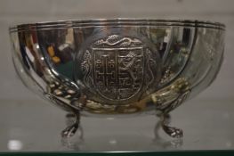 An unusual Continental silver circular bowl on four scroll feet, the body embossed with heraldic