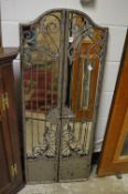 Decorative wrought iron mirror with hinged panels.