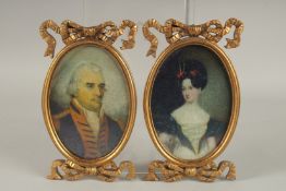 A LARGE PAIR OF GEORGIAN STYLE OVAL PORTRAIT MINIATURES in gilt frames. 7ins x 4.5ins.