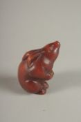 A CARVED HARDWOOD RABBIT NETSUKE. Signed. 2cms.