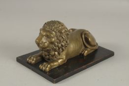 A REGENCY BRONZE LION on a wooden base. 7cms long.