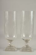 A PAIR OF CUT GLASS STORM LANTERNS on stepped bases. 15.5ins high.