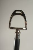 A WOODEN WALKING STICK WITH STIRRUP HANDLE.