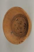 A CARVED WOOD BOWL SHAPE BUTTER PAT. 18cms diameter.
